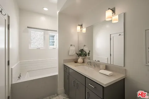 a bathroom with a sink a light fixture and a mirror