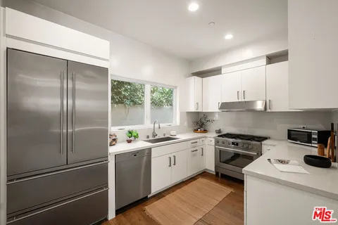 a kitchen with a sink a refrigerator and cabinets
