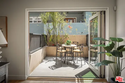 a dining room with furniture a rug and a floor to ceiling window