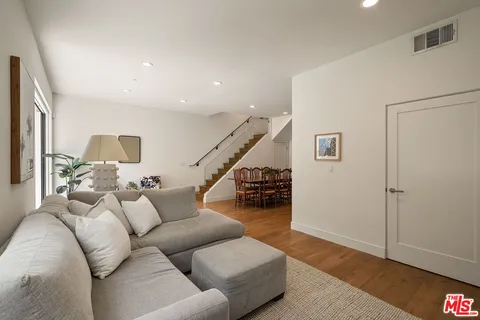 a living room with furniture and wooden floor