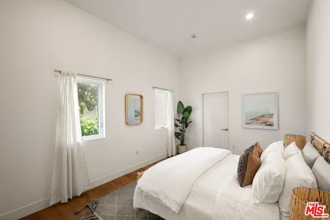a bedroom with a bed and wooden floor