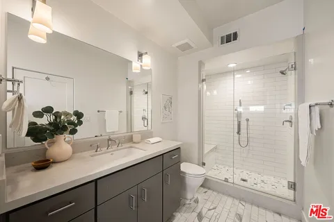 a bathroom with a double vanity sink mirror and shower