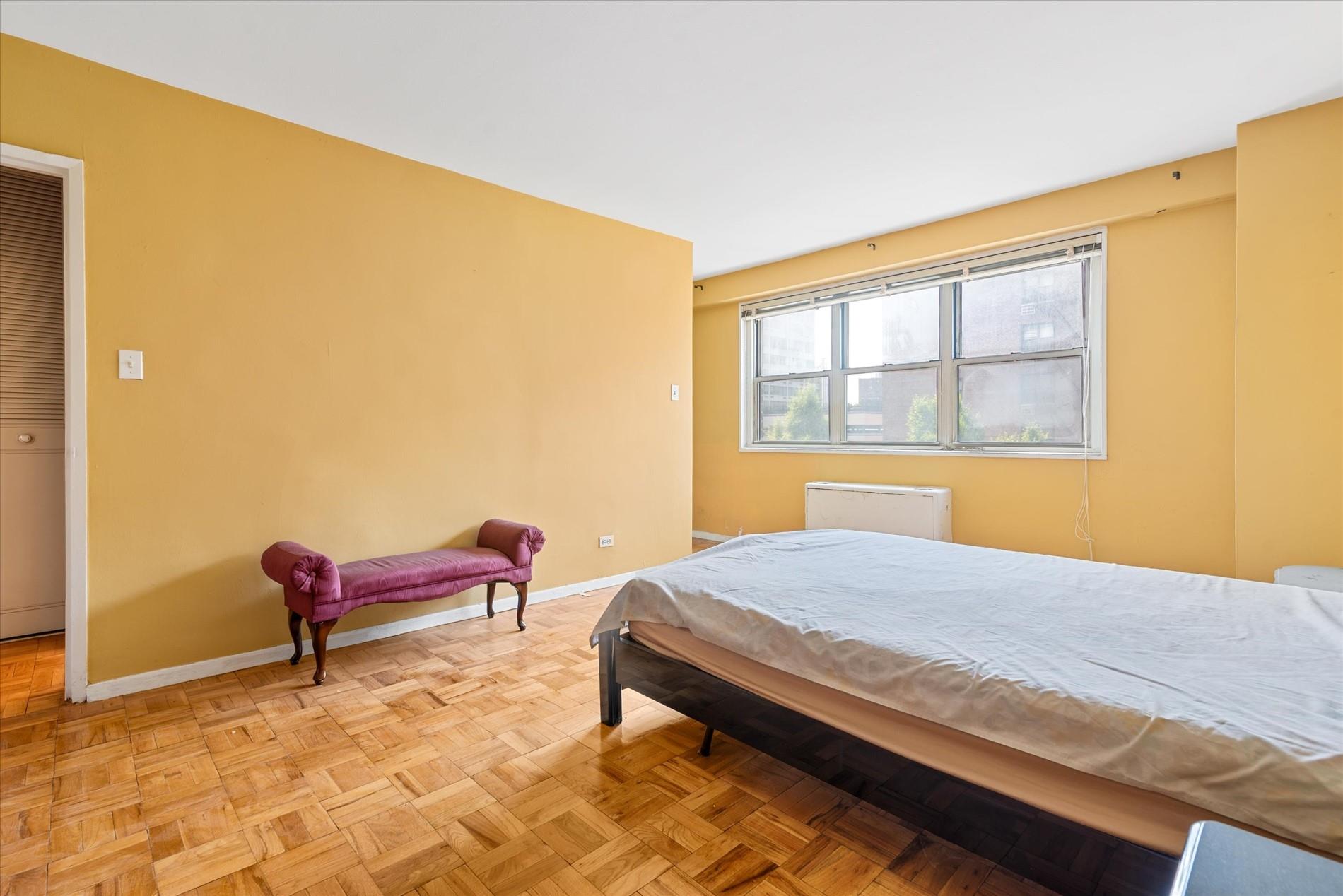 102-30 66th Road, Unit 4B Queens, NY 11375 - Photo 12 of 26 a bedroom with a bed and a chair