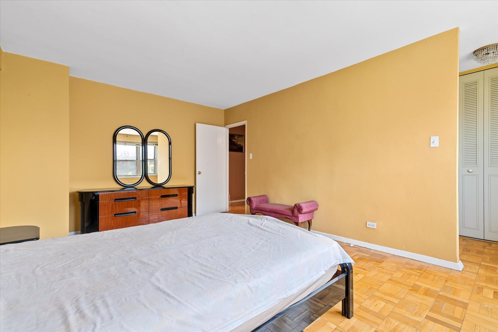 102-30 66th Road, Unit 4B Queens, NY 11375 - Photo 14 of 26 a bed room with a bed and a dresser with mirror