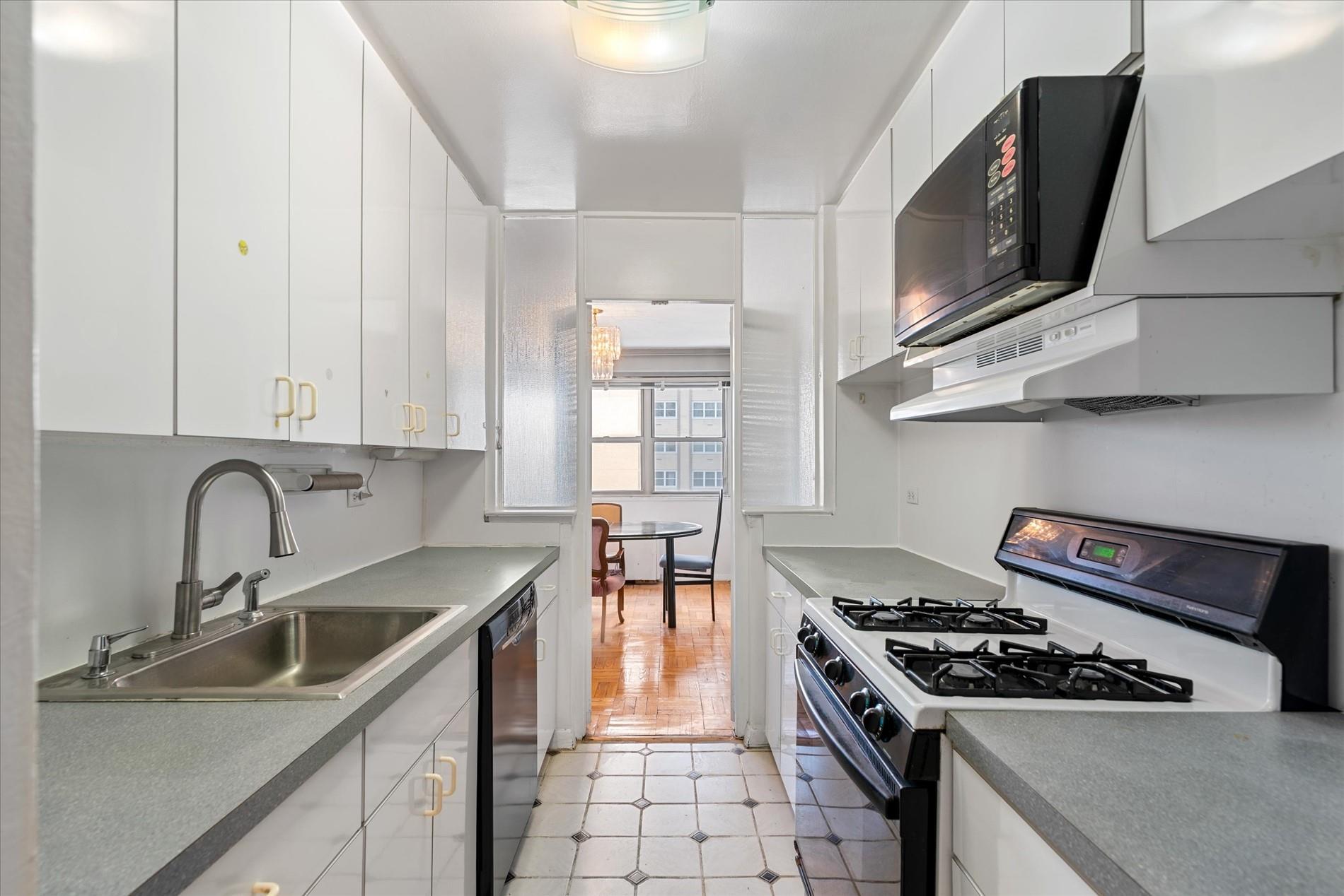 102-30 66th Road, Unit 4B Queens, NY 11375 - Photo 6 of 26 a kitchen with granite countertop a stove and a sink