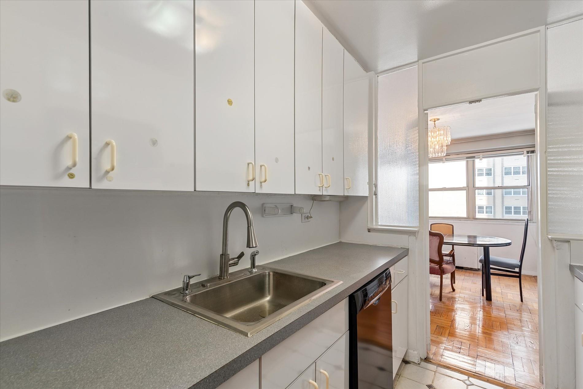 102-30 66th Road, Unit 4B Queens, NY 11375 - Photo 7 of 26 a kitchen with granite countertop a sink a stove and cabinets