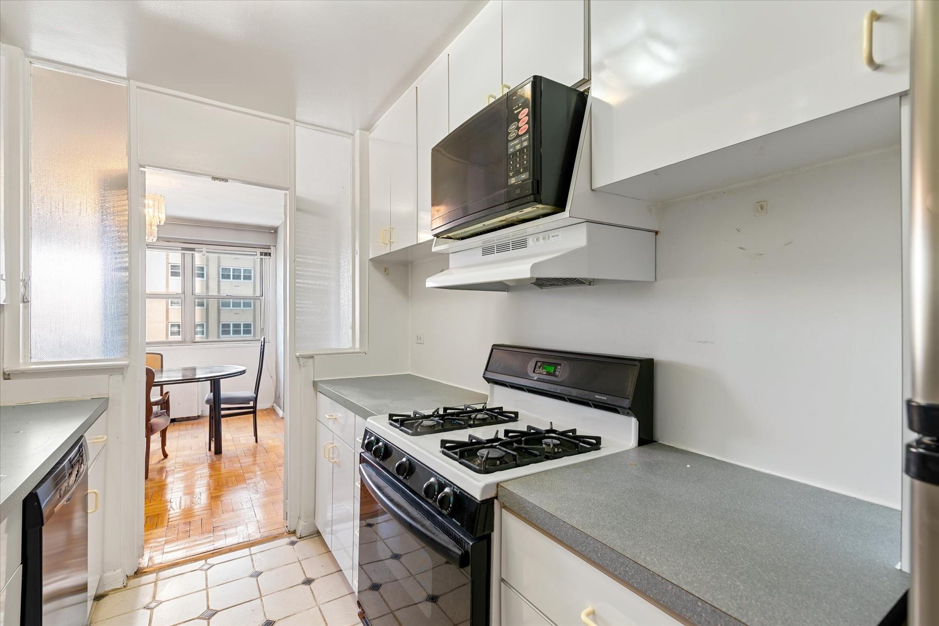 102-30 66th Road, Unit 4B Queens, NY 11375 - Photo 8 of 26 a kitchen with a stove and a microwave