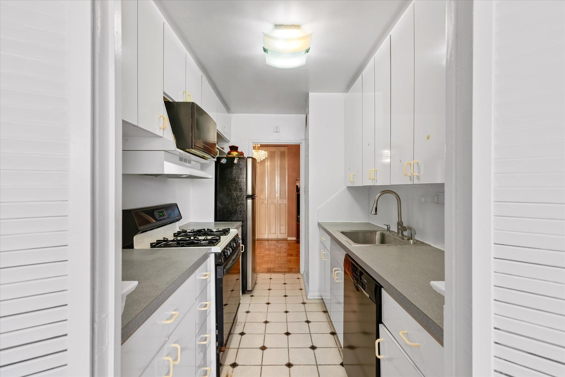 102-30 66th Road, Unit 4B Queens, NY 11375 - Photo 9 of 26 a kitchen with stainless steel appliances a sink stove and refrigerator
