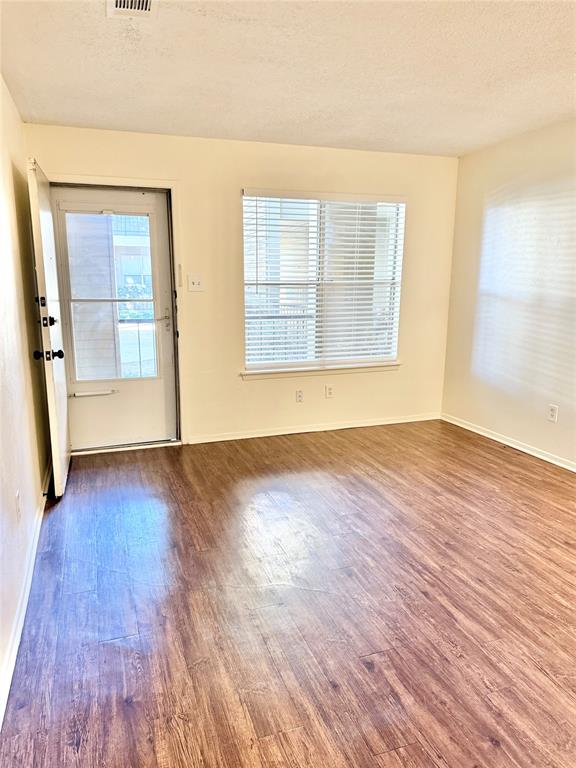 222 North Center Street, Unit 106 Grand Prairie, TX 75050 - Photo 4 of 8 an empty room with wooden floor and windows