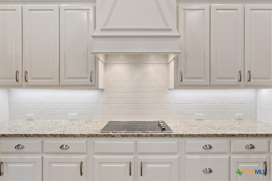 4 Salta Court Belton, TX 76513 - Photo 23 of 45 a kitchen with granite countertop white cabinets and a white stainless steel appliances