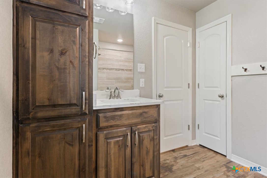 4 Salta Court Belton, TX 76513 - Photo 38 of 45 a bathroom with a granite countertop sink a mirror and a shower
