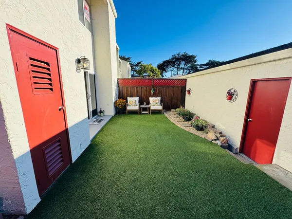 a view of a backyard with chairs and a small cabin