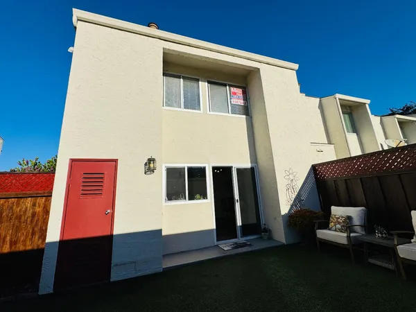 a backyard of a house with wooden floor and a potted plant
