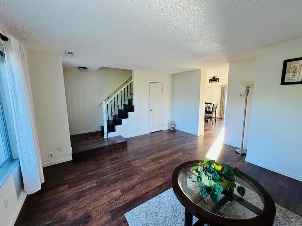 a view of a hallway with wooden floor and furniture