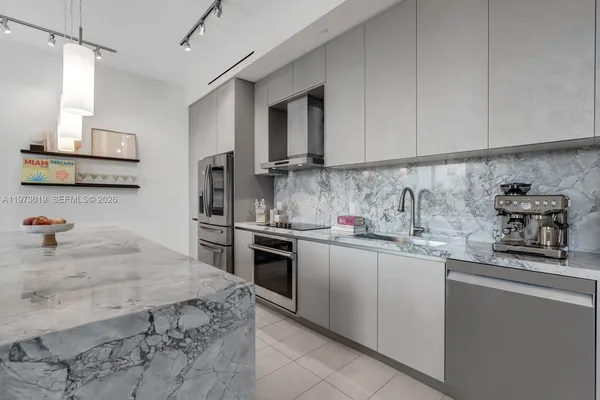 a kitchen with stainless steel appliances granite countertop a sink stove oven and white cabinets