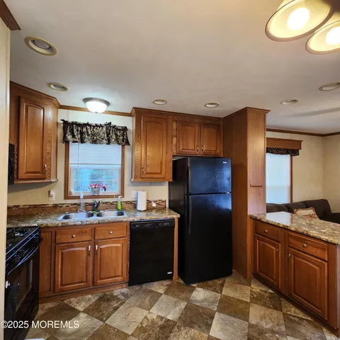 a kitchen with stainless steel appliances granite countertop a stove a refrigerator and a sink