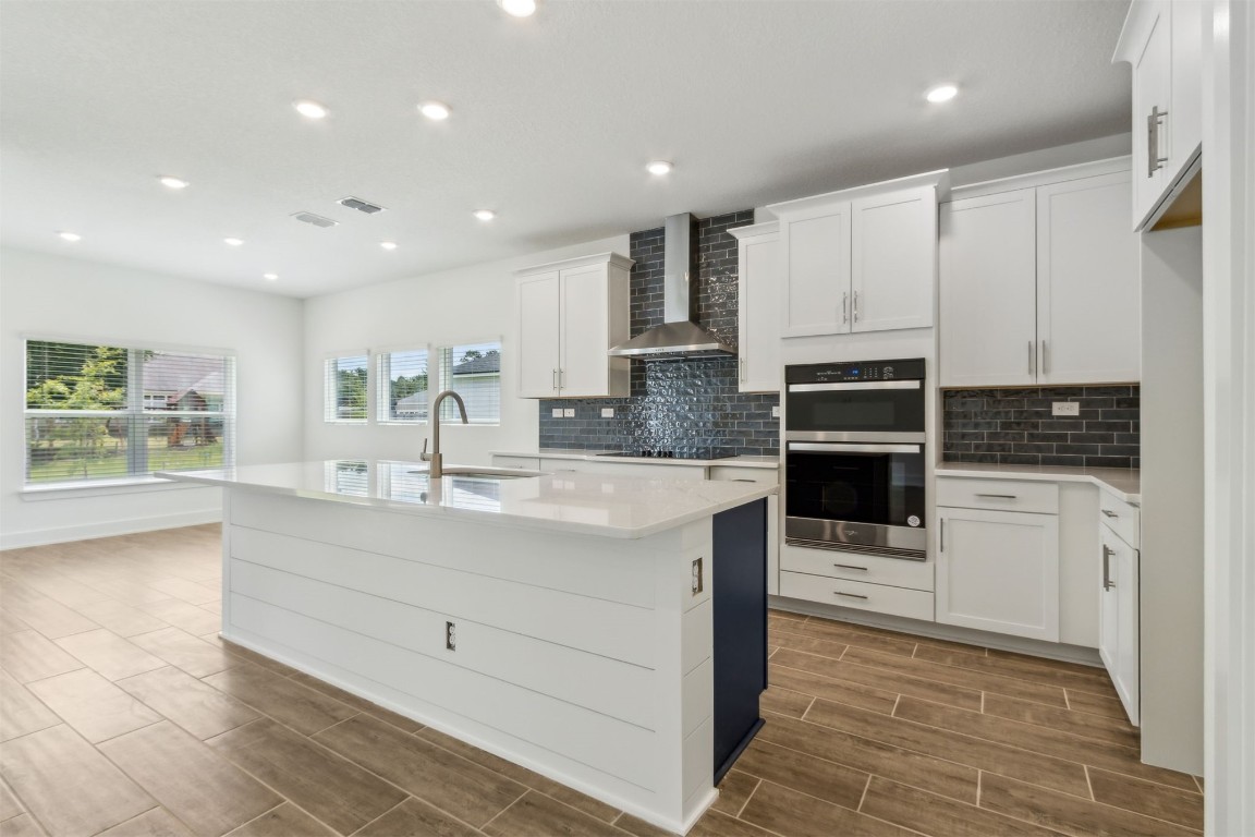 96100 Pirates Bluff Road Yulee, FL 32097 - Photo 9 of 39 a large kitchen with stainless steel appliances a large counter top a stove and a refrigerator