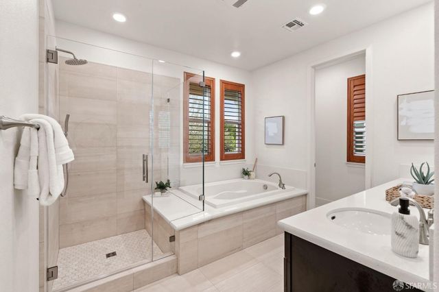 a bathroom with a bathtub shower sink vanity and toilet