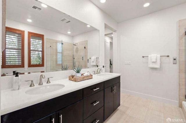 a bathroom with double vanity sinks double vanity tub and a mirror