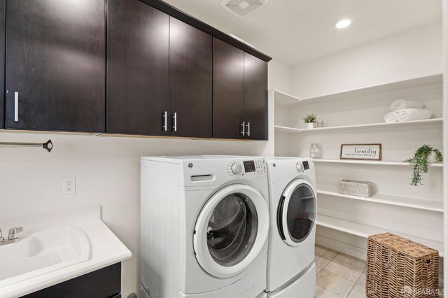a utility room with cabinets dryer and washer