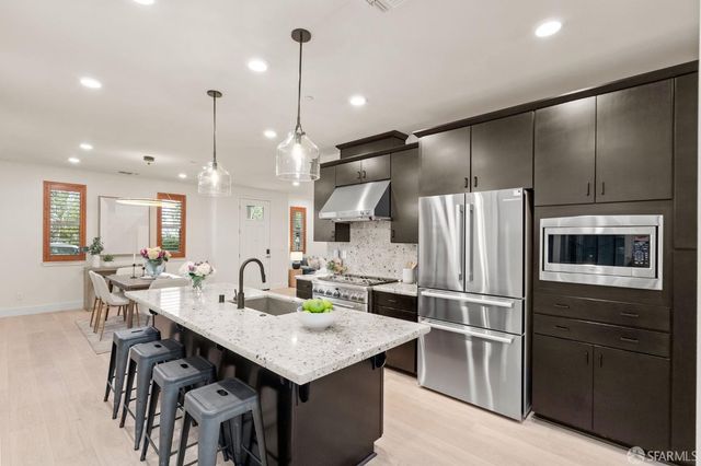 a kitchen with kitchen island a refrigerator stove microwave and cabinets