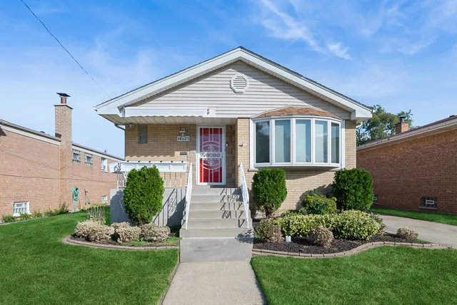 a front view of a house with a yard and potted plants