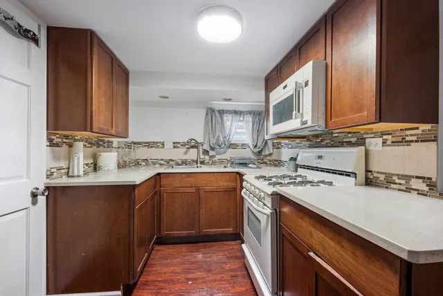 a kitchen with a sink stove top oven and cabinets