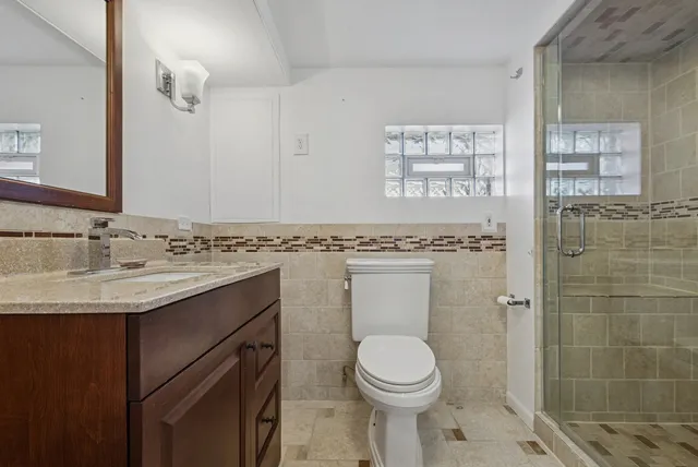 a bathroom with a granite countertop sink toilet and shower