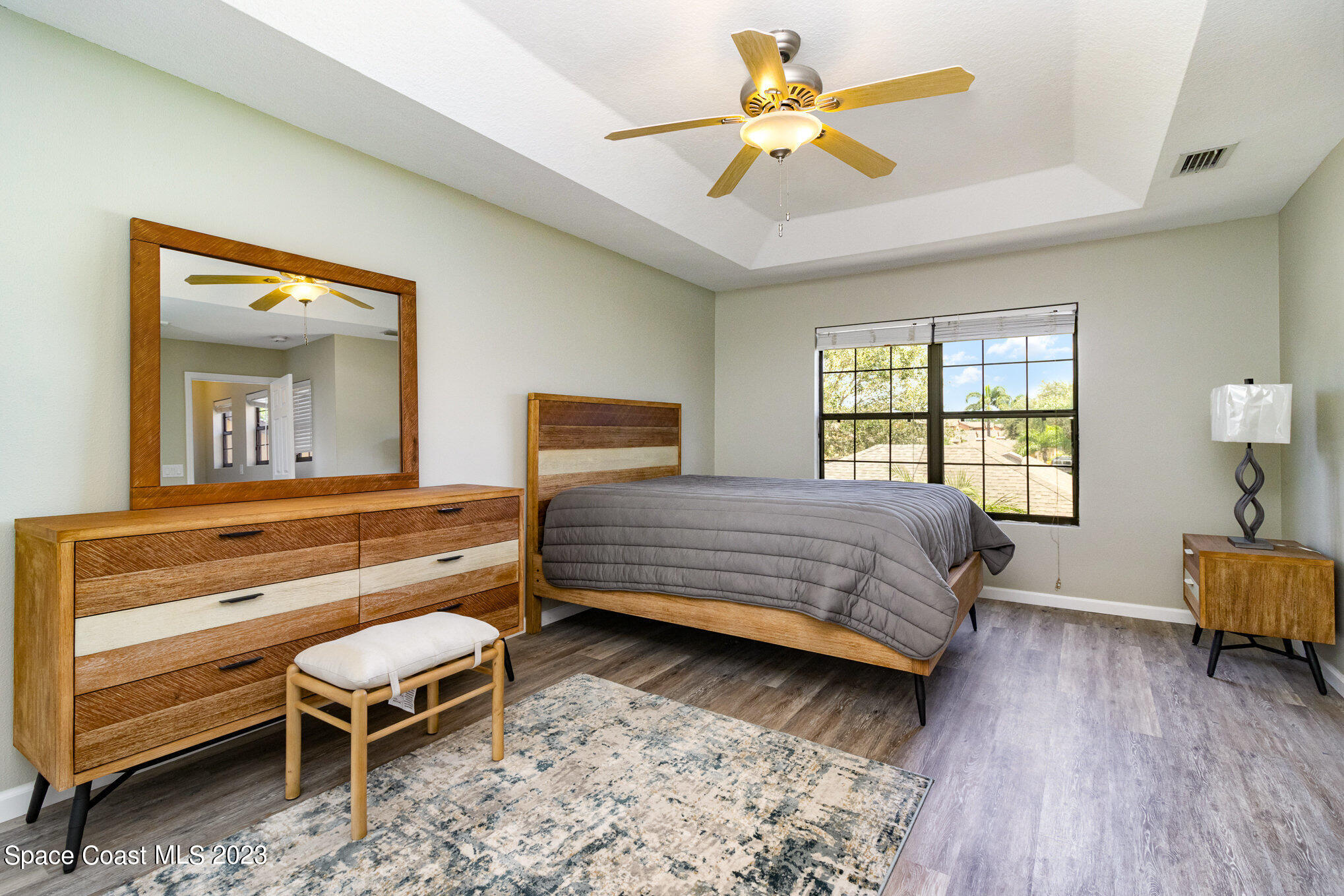 950 Luminary Circle, Unit 103 Melbourne, FL 32901 - Photo 12 of 23 a bedroom with a bed and a dresser next to a window