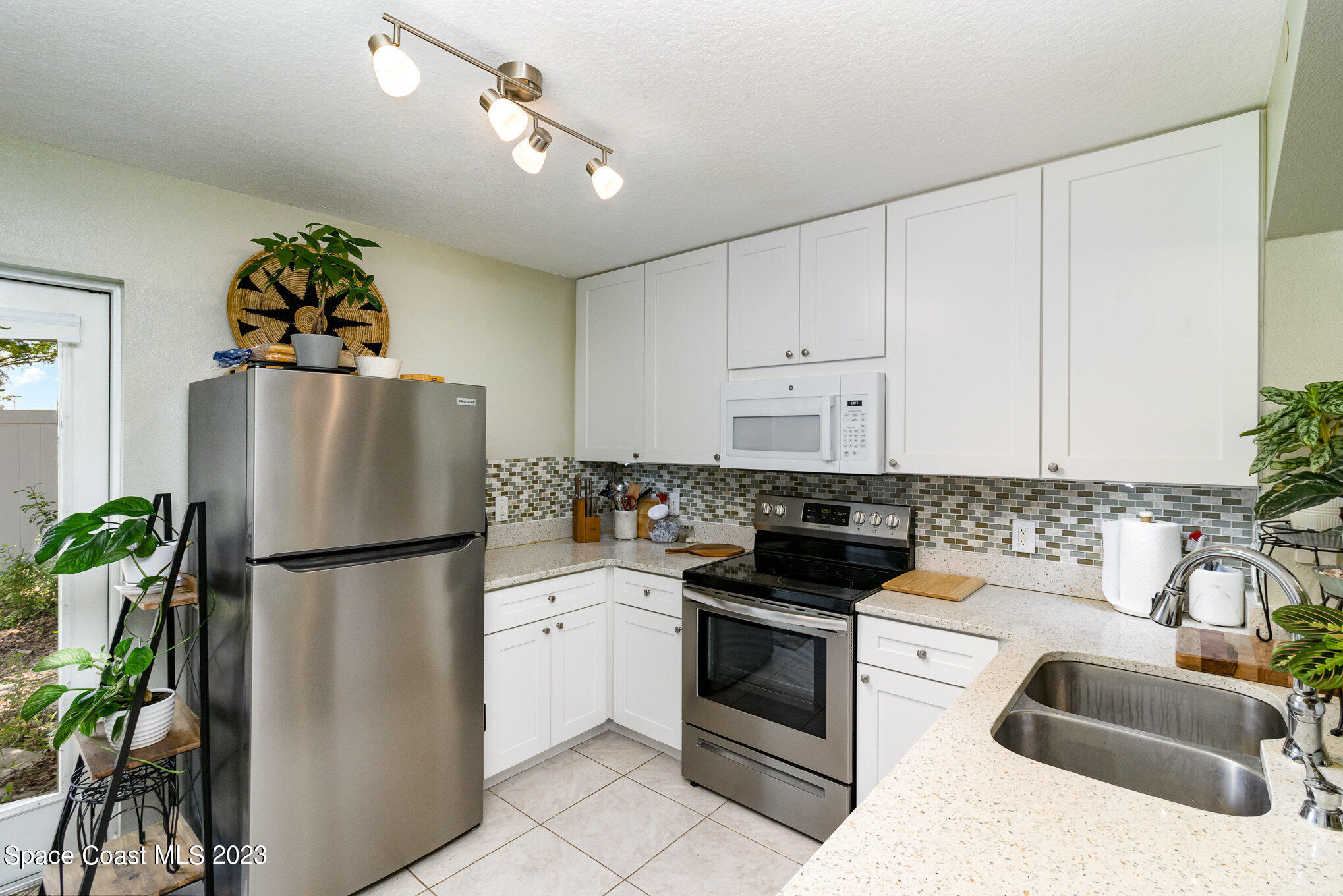 950 Luminary Circle, Unit 103 Melbourne, FL 32901 - Photo 6 of 23 a kitchen with stainless steel appliances granite countertop a refrigerator a stove a sink and a refrigerator