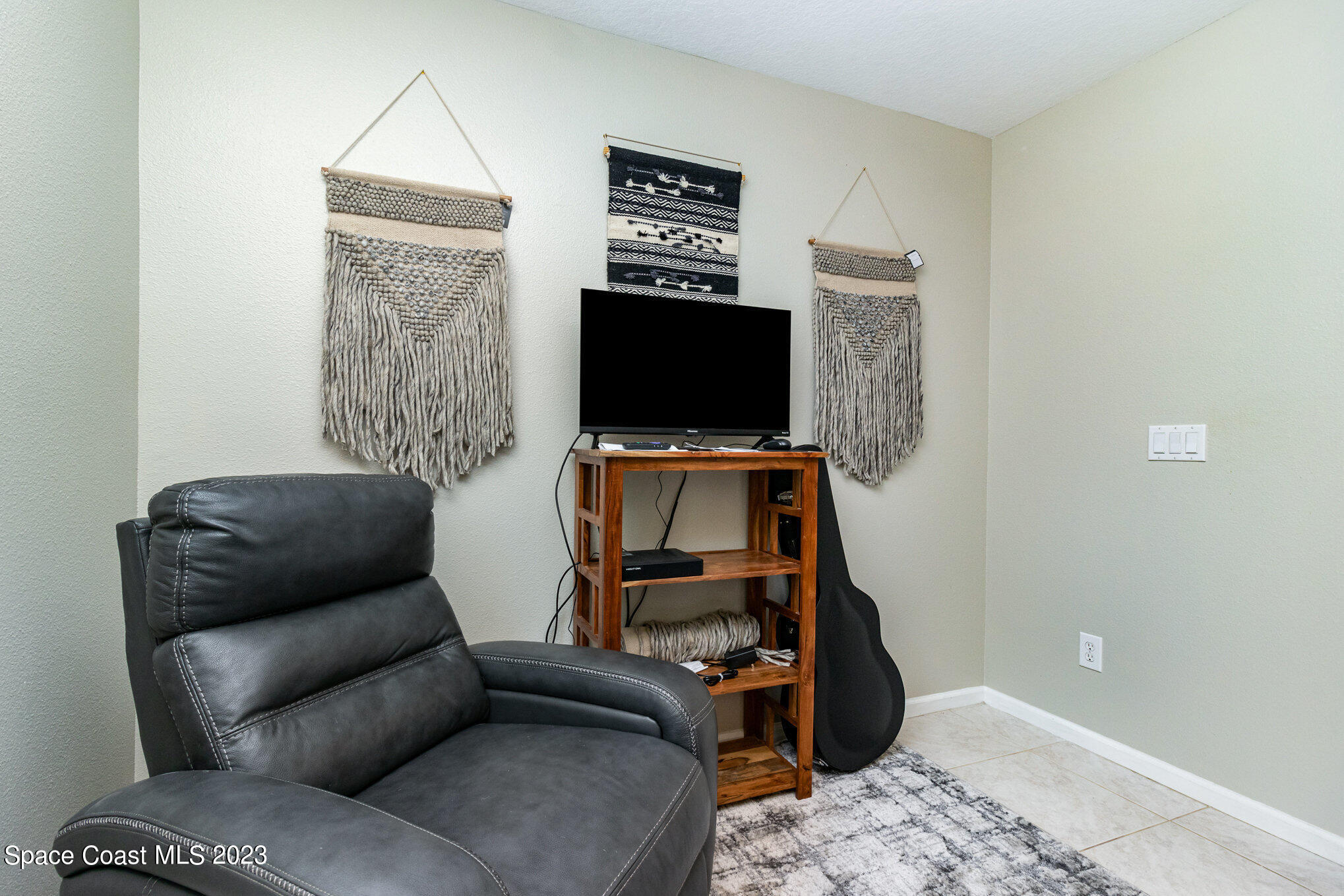 950 Luminary Circle, Unit 103 Melbourne, FL 32901 - Photo 9 of 23 a living room with furniture and a flat screen tv