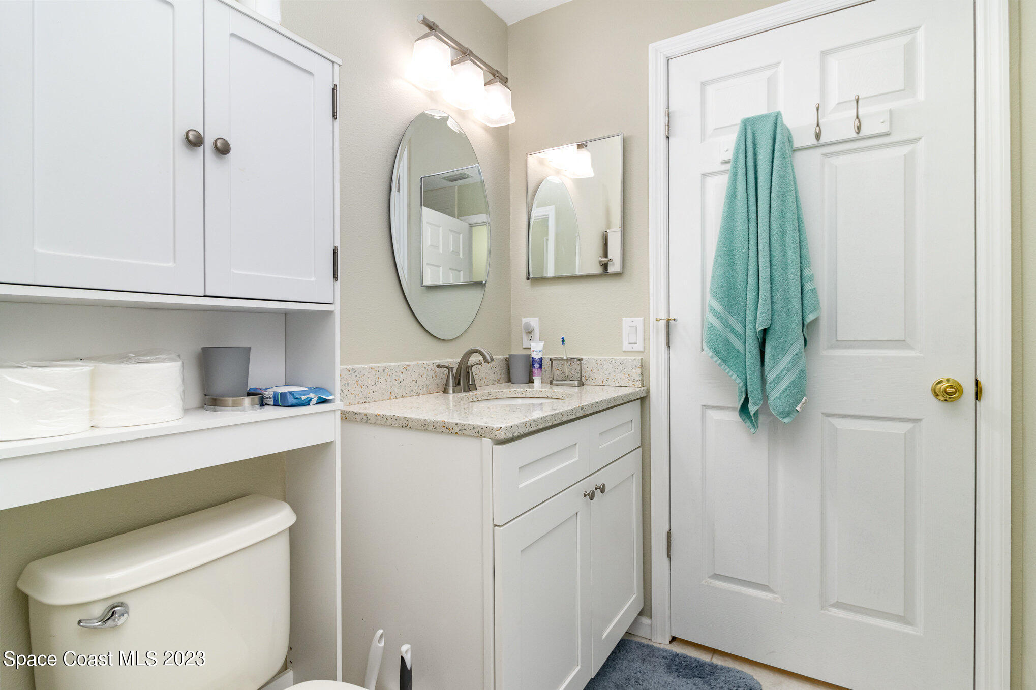 950 Luminary Circle, Unit 103 Melbourne, FL 32901 - Photo 10 of 23 a bathroom with a granite countertop toilet sink and mirror