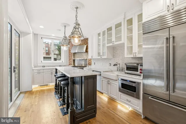 a kitchen with stainless steel appliances granite countertop a sink a stove and a refrigerator
