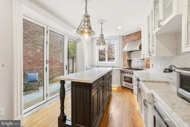 a kitchen with granite countertop a stove a sink dishwasher and a refrigerator with wooden floor