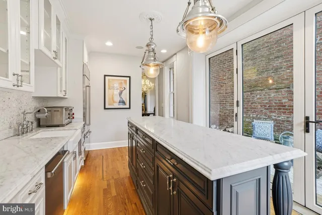 a kitchen with granite countertop a stove a sink dishwasher and a refrigerator with wooden floor