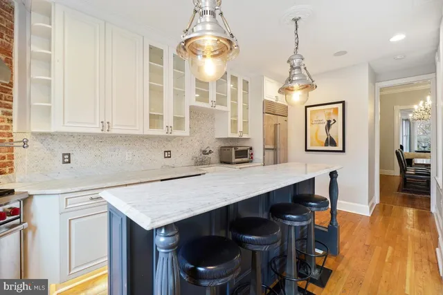 a kitchen with a table chairs sink and cabinets