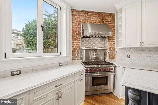 a kitchen with a sink stove top oven and cabinets