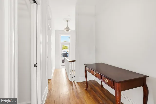 a living room with a bed and wooden floor