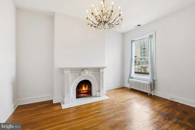 an empty room with wooden floor and fireplace