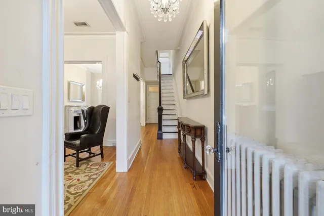 a view of a hallway with wooden floor and stairs