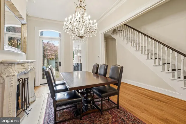 a view of a dining room with furniture a chandelier and wooden floor