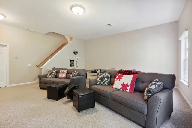 a living room with furniture and stairs