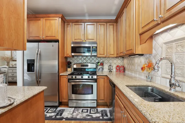 a kitchen with stainless steel appliances granite countertop a stove a sink and a refrigerator