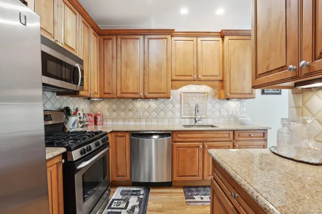 a kitchen with stainless steel appliances granite countertop a stove a sink and a microwave