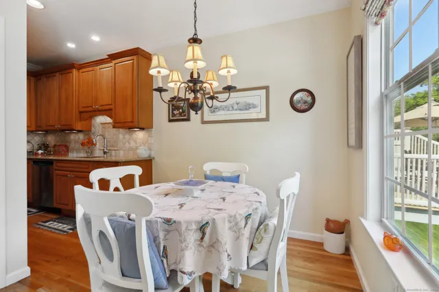a view of a dining room with furniture a chandelier and wooden floor