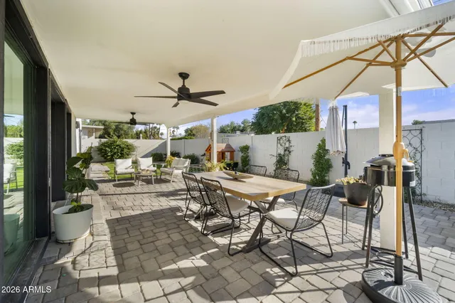 a view of a white house with a big yard and potted plants