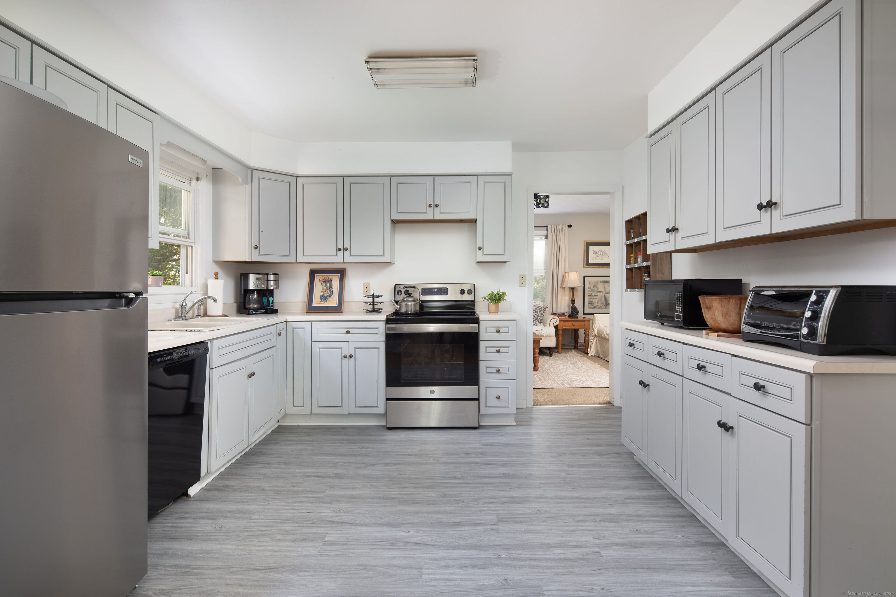37 Greene Avenue North Canaan, CT 06018 - Photo 2 of 17 a kitchen with granite countertop a refrigerator oven a sink dishwasher and white cabinets with wooden floor