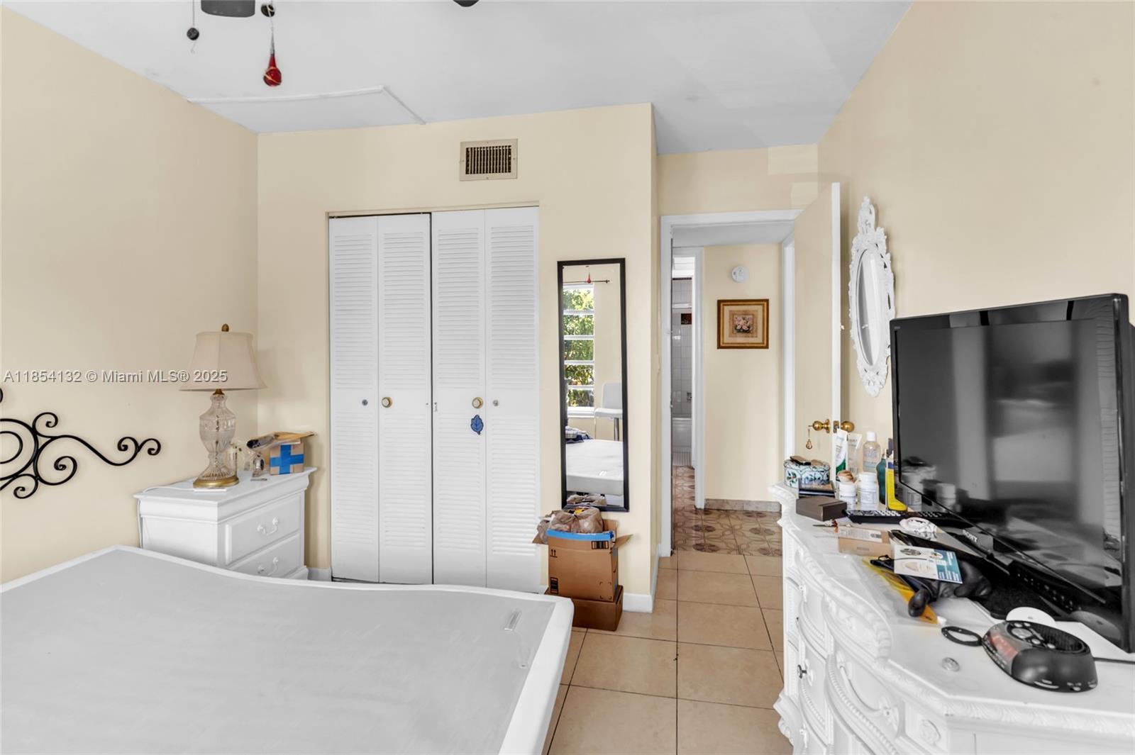 1855 West 62nd Street, Unit E306 Hialeah, FL 33012 - Photo 15 of 35 a living room with furniture and a flat screen tv