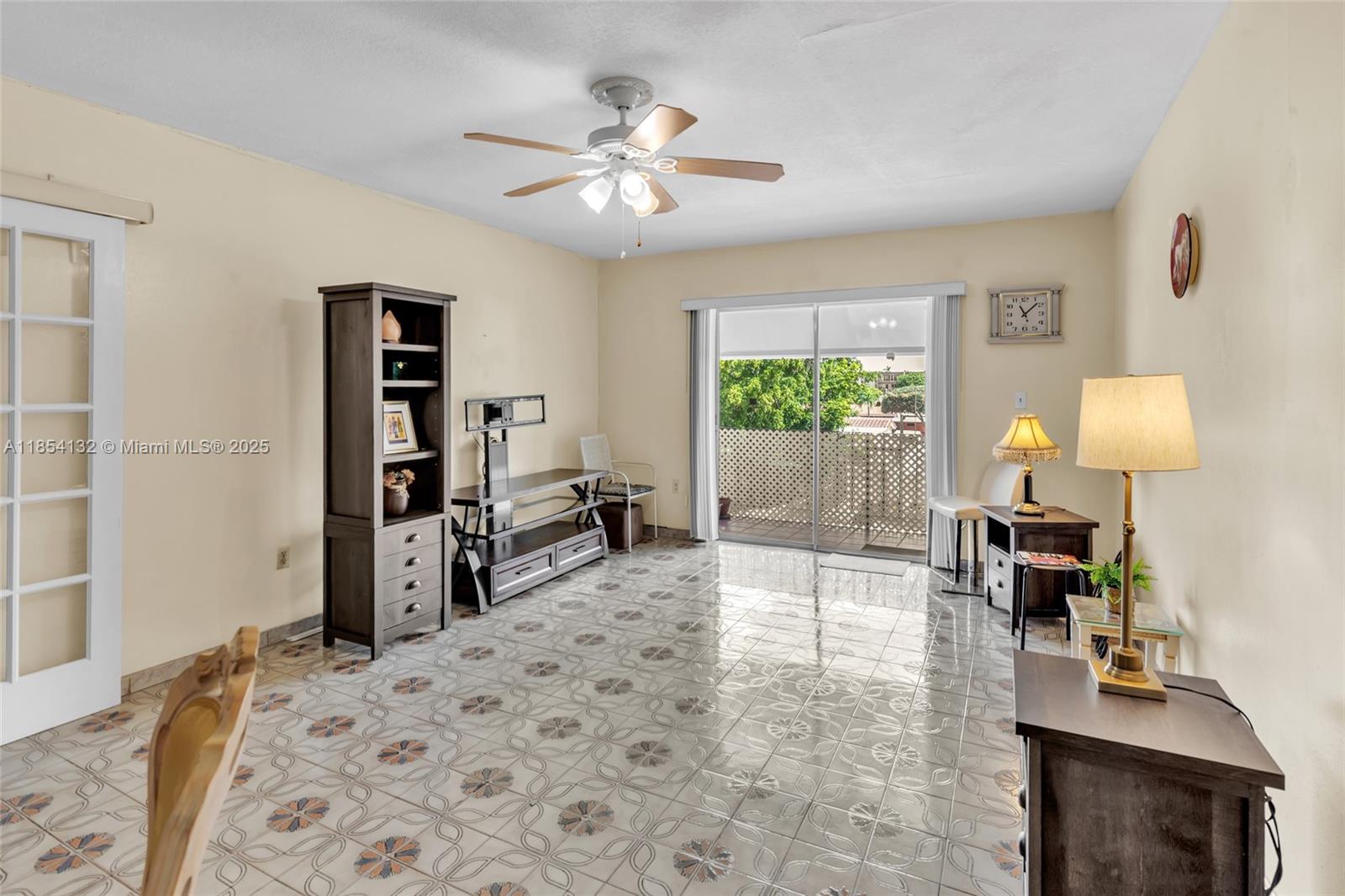 1855 West 62nd Street, Unit E306 Hialeah, FL 33012 - Photo 2 of 35 a living room with furniture a window and a table