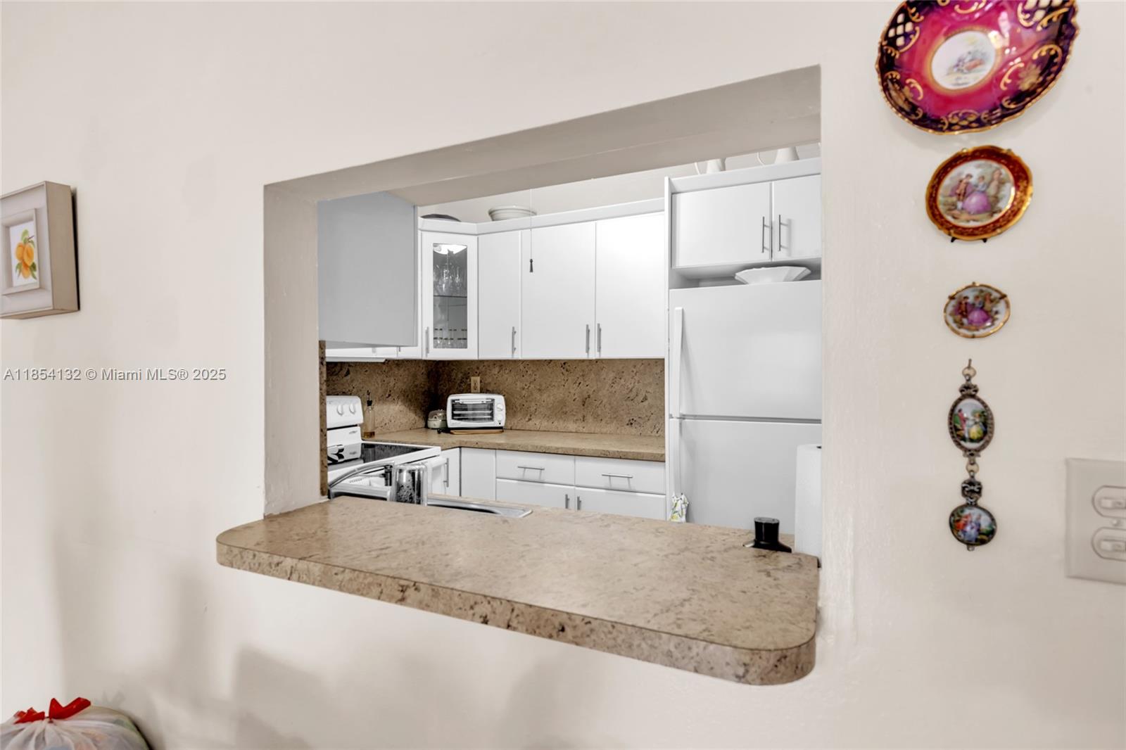 1855 West 62nd Street, Unit E306 Hialeah, FL 33012 - Photo 5 of 35 a kitchen with a refrigerator and a stove